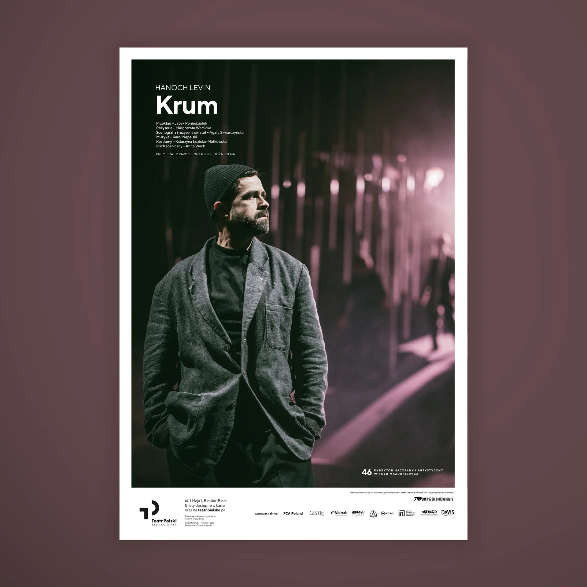 Na zdjęciu - plakat spektaklu "Krum". W centrum - brunet w średnim wieku, w szarej marynarce. W lewym górnym rogu informacje: Hanoch Lewin, Krum. 
