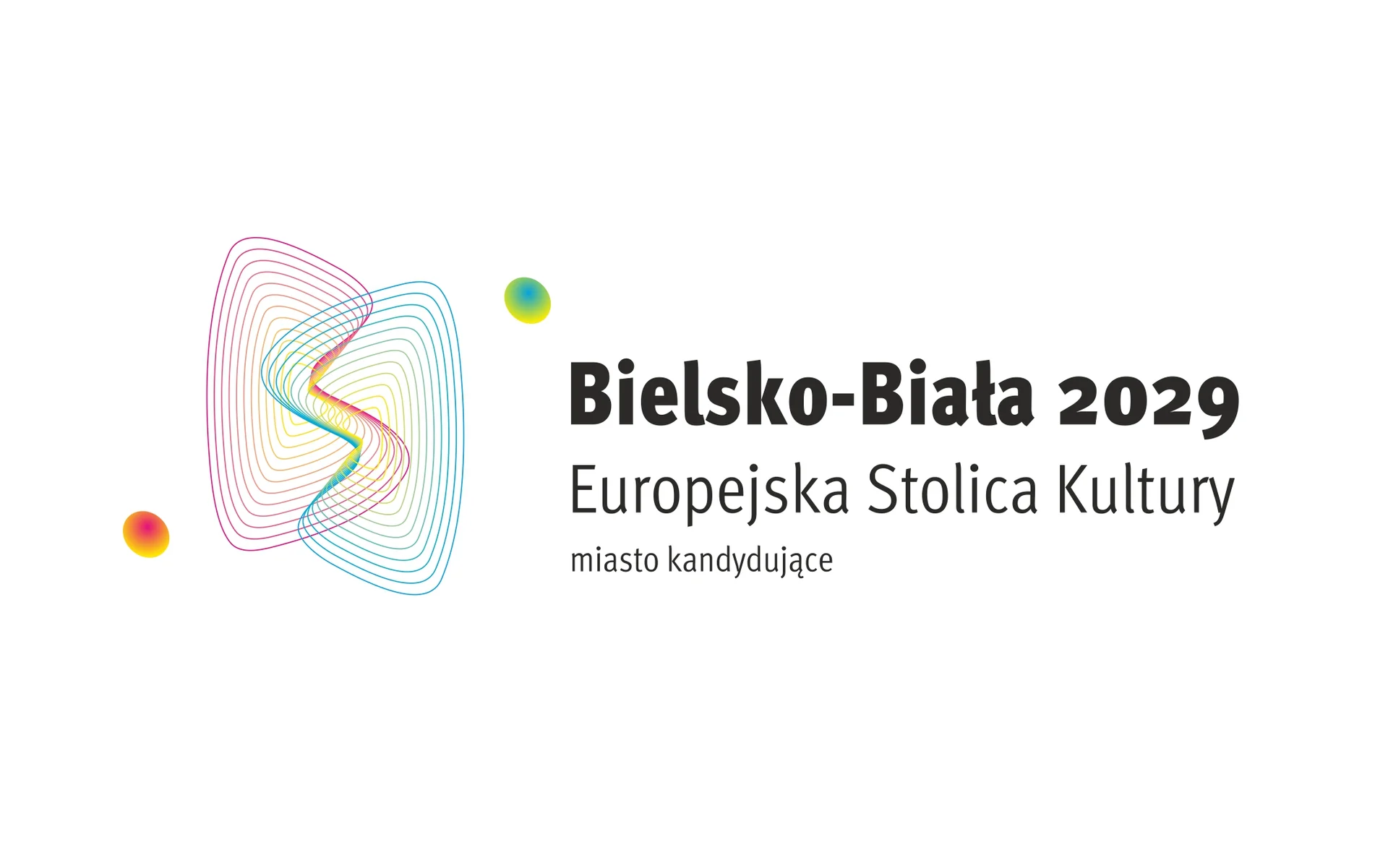 Logotyp - czarny napis na białym tle: Bielsko-Biała 2029 Europejska Stolica Kultury. Miasto kandydujące. Obok grafiki w formie splatających się kolorowych linii - dwa małe kółka - zielone i pomarańczowe.  