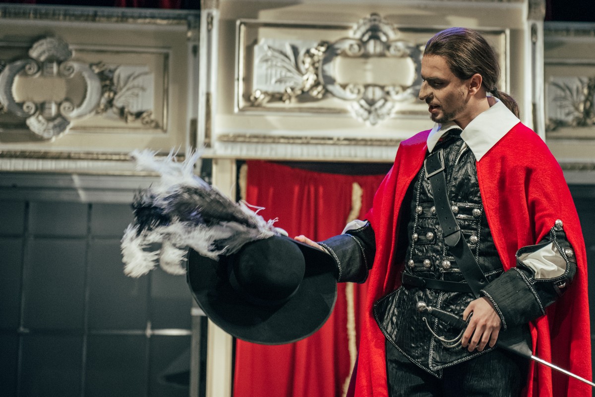 Michał Czaderna stoi na scenie, w kostiumie Cyrano de Bergerac. 